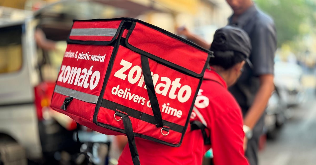 bloombergquint2F2025-04-022Fqo6eo4v32FZomato-Ltd.s-delivery-woman-rider-waiting-on-street-to-pick.jpeg