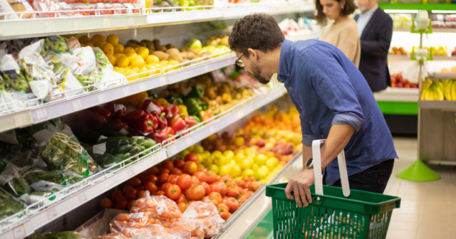 A_man_looks_over_produce_in_a_grocery_store.png