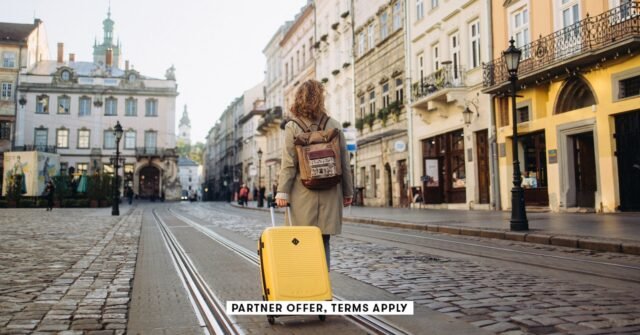 SOCIAL-IMAGE_PARTNER-OFFER-TERMS-APPLY_woman-with-a-suitcase-walking-on-European-street_Nazar-Rybak.jpeg